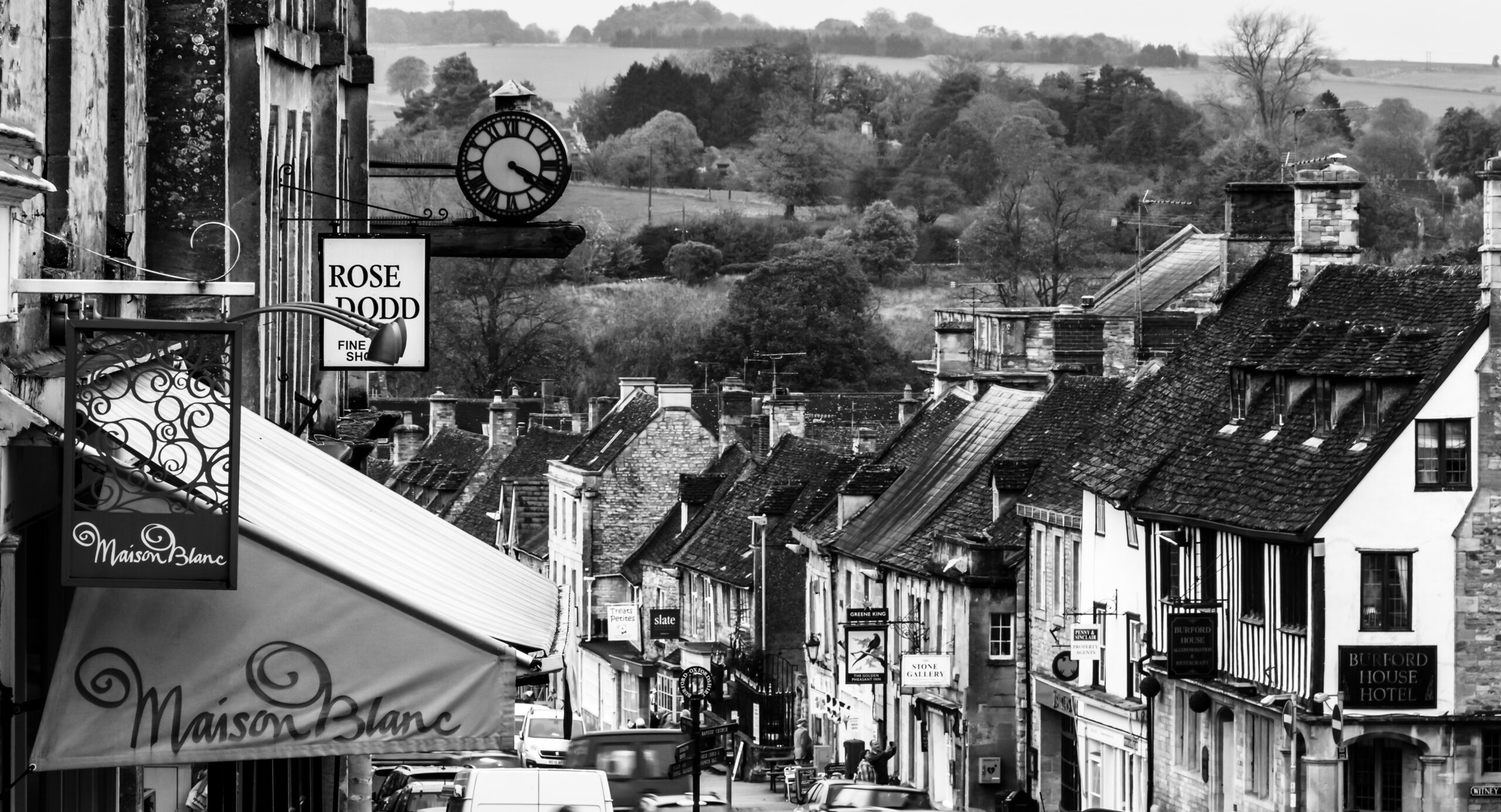 Burford High Street in the Cotswolds, England, with historic stone buildings and boutique shops