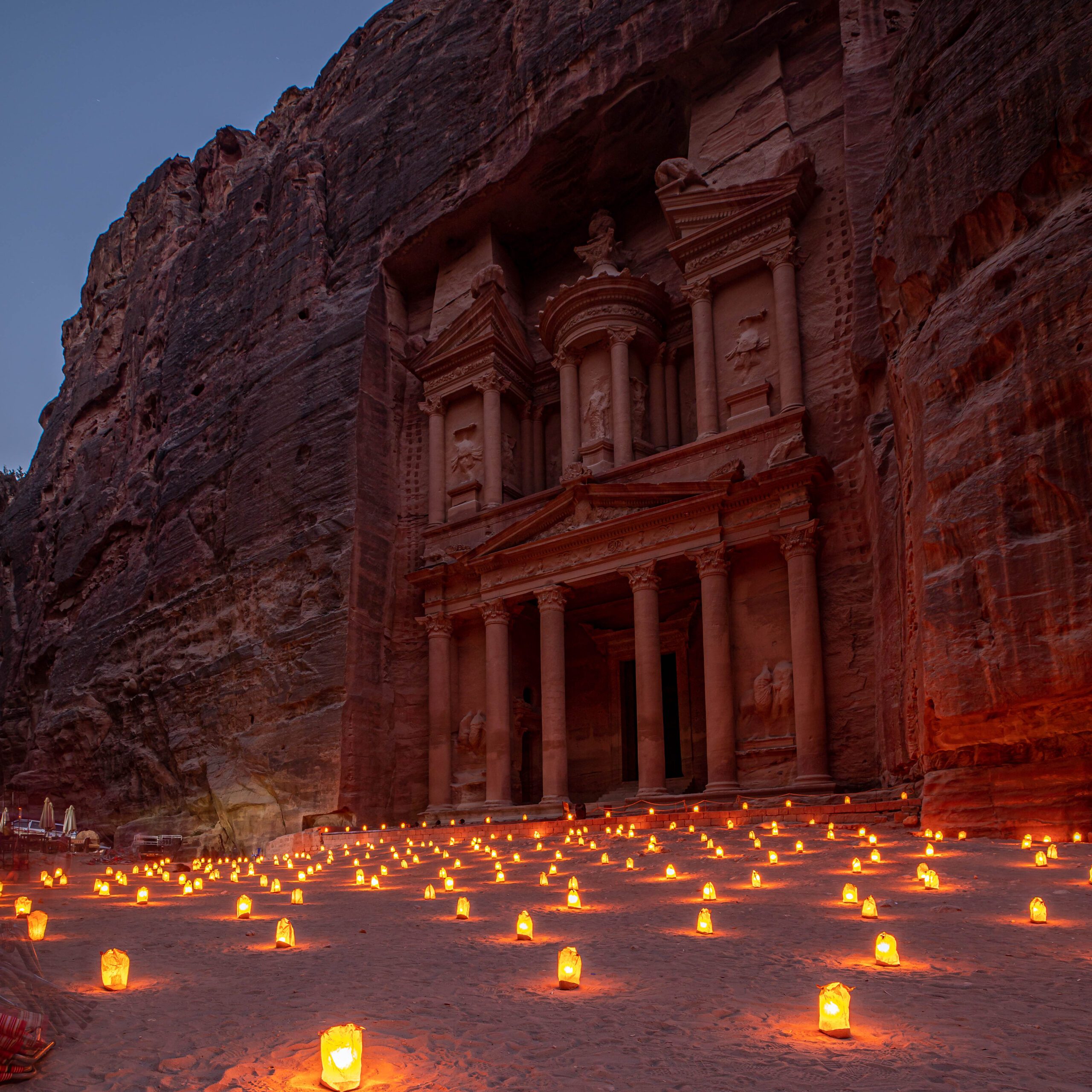 Petra Treasury in Jordan illuminated by hundreds of candles during Petra by Night, creating a warm and atmospheric scene.