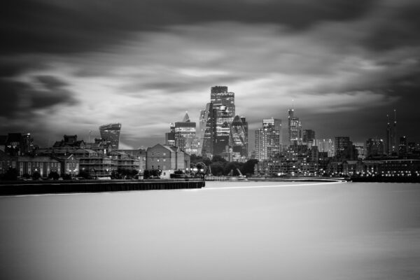 Black and white photograph of London City skyline viewed from Canary Wharf docks with modern skyscrapers