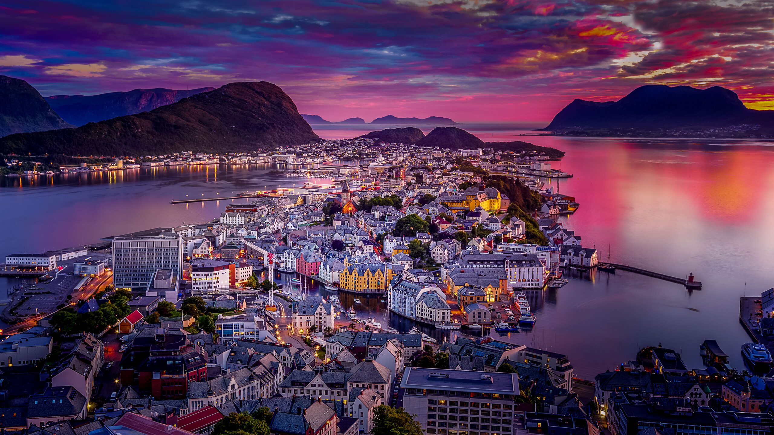Ålesund, Norway, viewed from a high viewpoint at sunset with vibrant colours lighting up the evening sky over the city and harbour