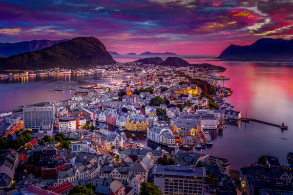 Ålesund, Norway, viewed from a high viewpoint at sunset with vibrant colours lighting up the evening sky over the city and harbour