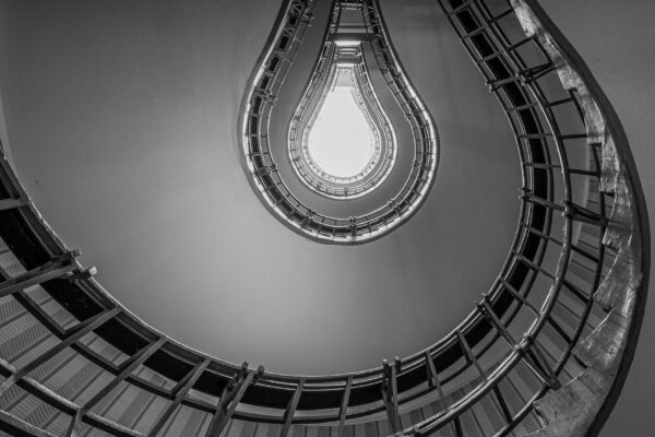 Bulb-shaped spiral staircase in Prague viewed from below, resembling a glowing light bulb