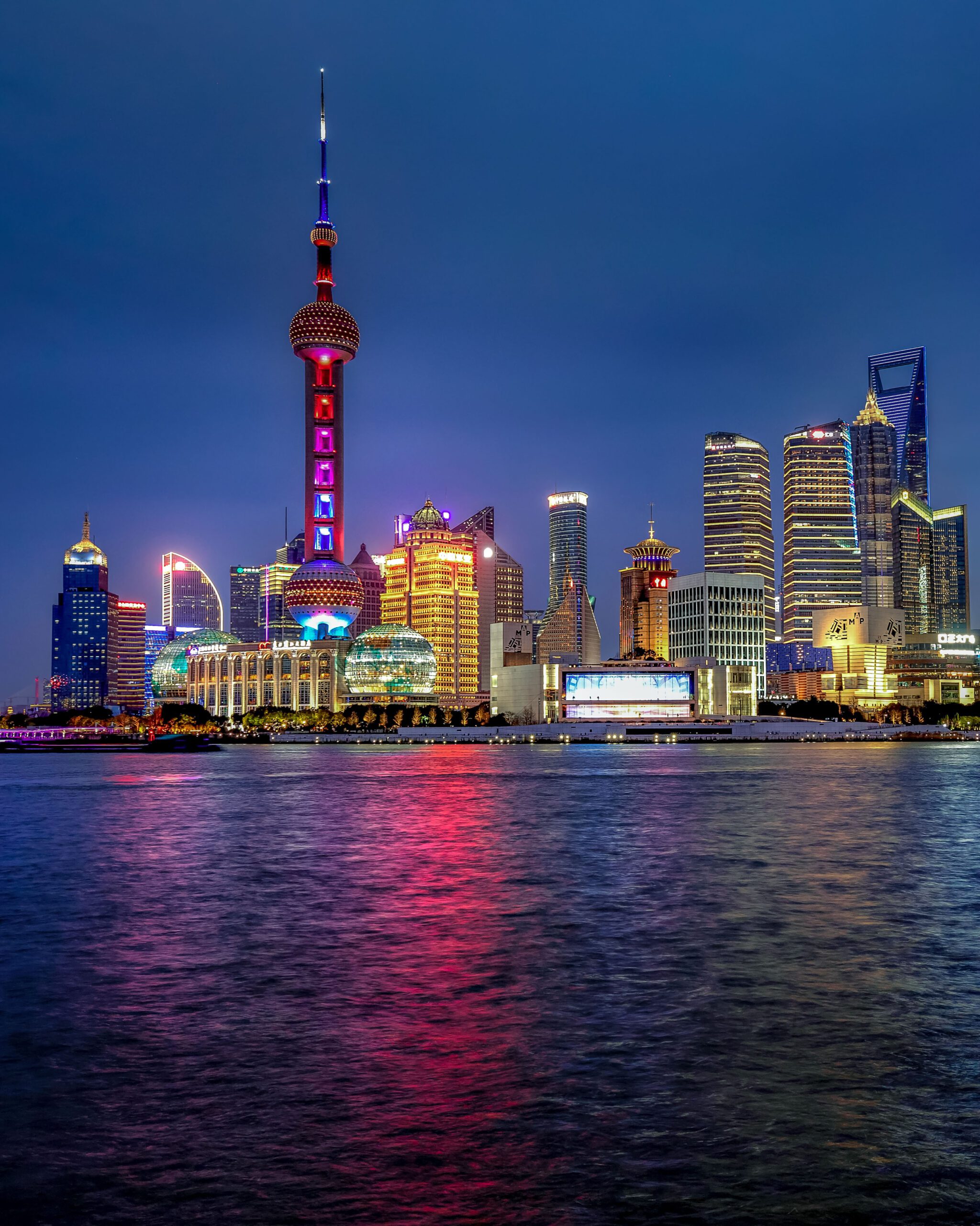 The Bund in Shanghai, China, during blue hour with historic waterfront buildings illuminated along the Huangpu River