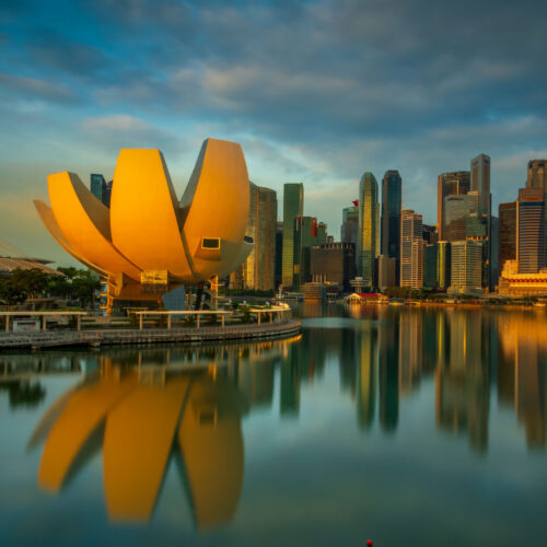 Marina Bay skyline in Singapore at night with illuminated buildings reflected in the water