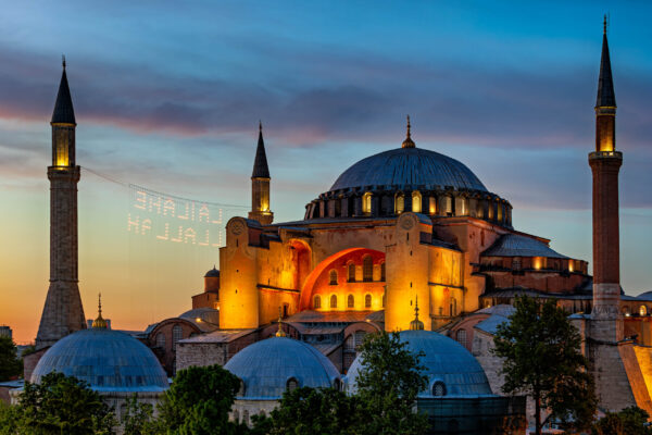 Hagia Sophia Grand Mosque in Istanbul, Turkey, at sunset with warm golden light on its domes and minarets